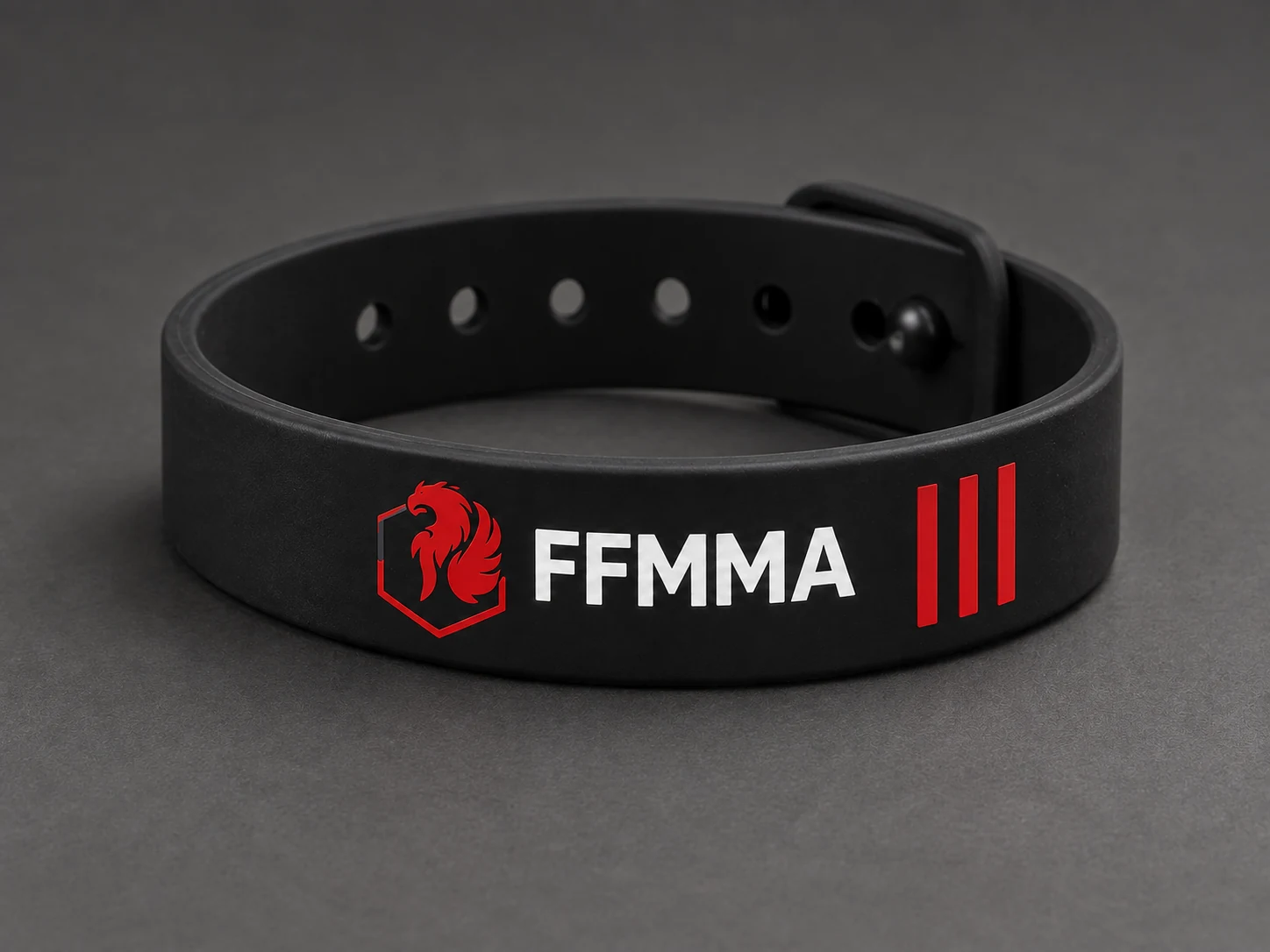 Black adjustable bracelet with a red FFMMA emblem, shown as a studio product concept.